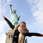 Jeune femme heureuse devant la statue de la liberté
