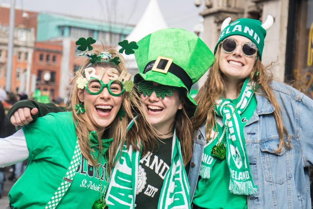 Trois jeunes femmes habillées en vert qui célébrant la Saint-Patrick