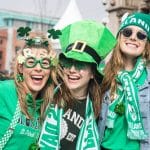 Trois jeunes femmes habillées en vert qui célébrant la Saint-Patrick