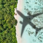 Ombre d'avion survolant une plage paradisiaque