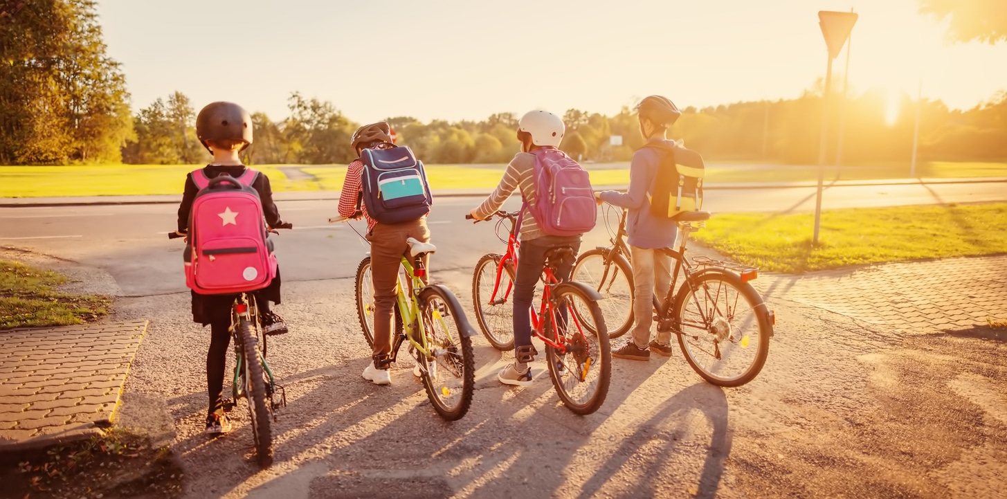 quatre enfants qui vont à l'école en vélo