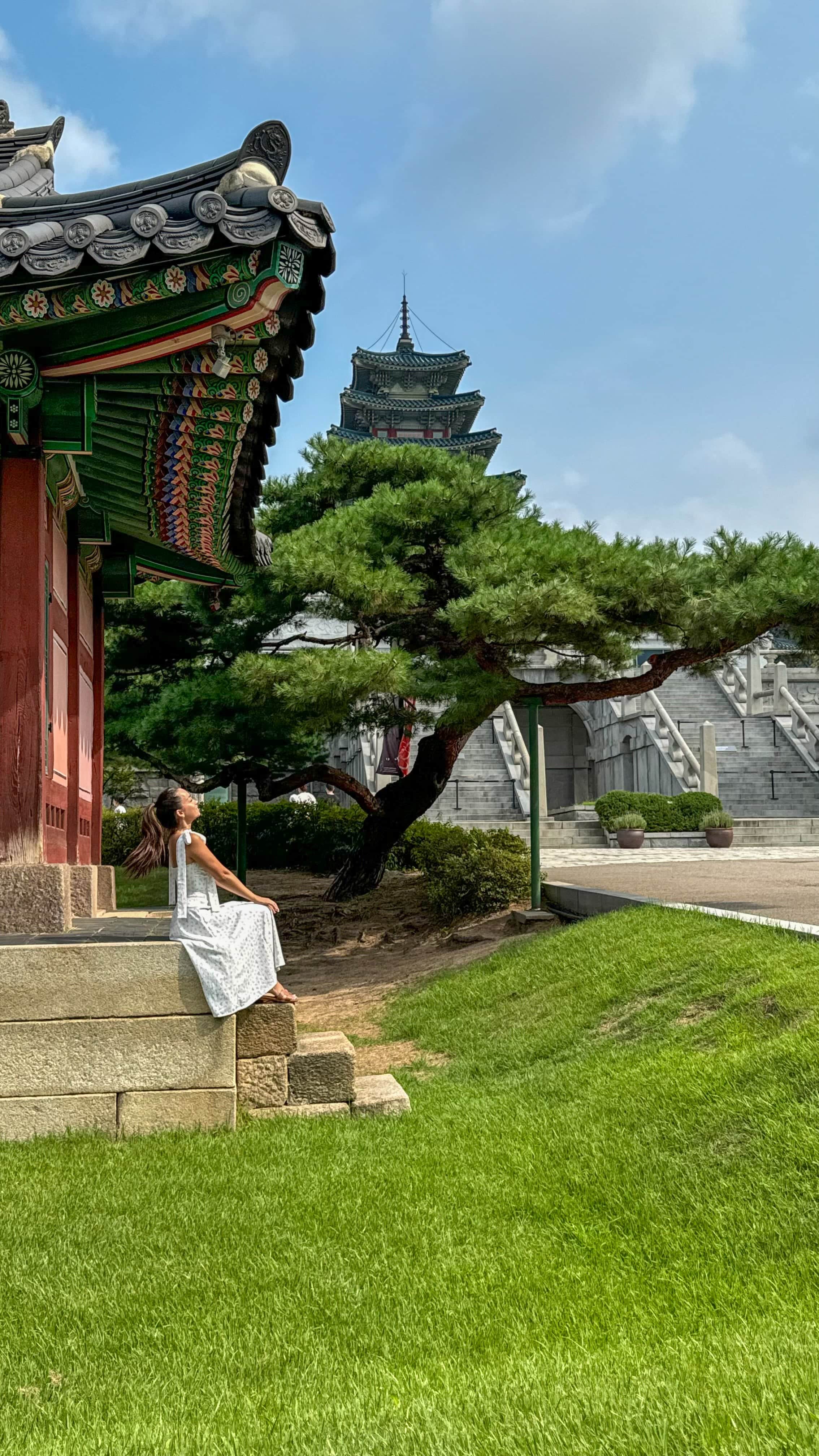 Jeune femme assise devant un temple à Séoul