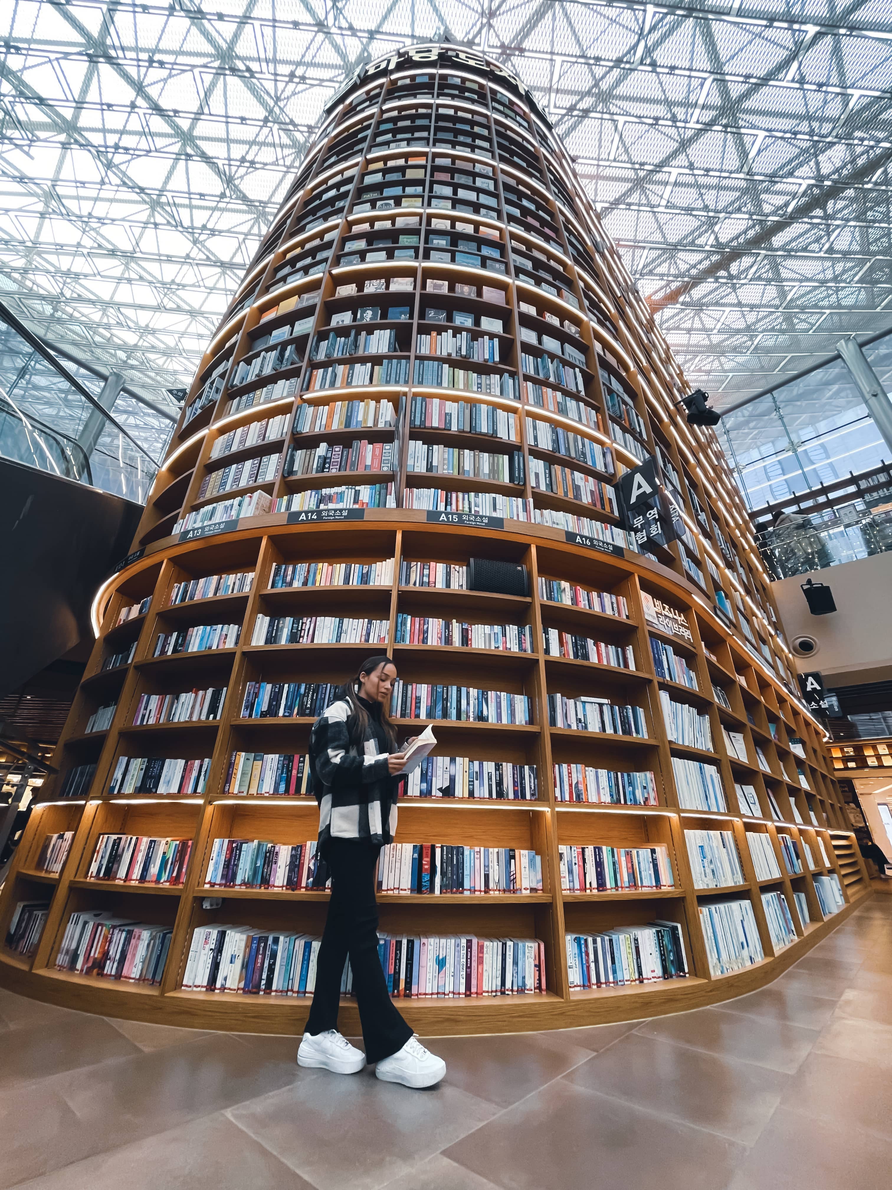 Jeune femme se tenant devant la bibliothèque Starfield COEX de Séoul
