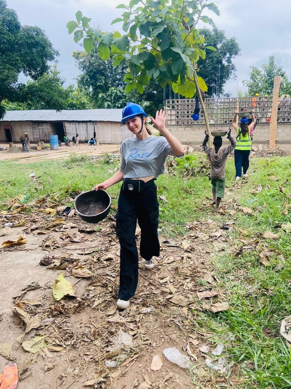 Jeune femme portant un casque de chantier dans un village africain