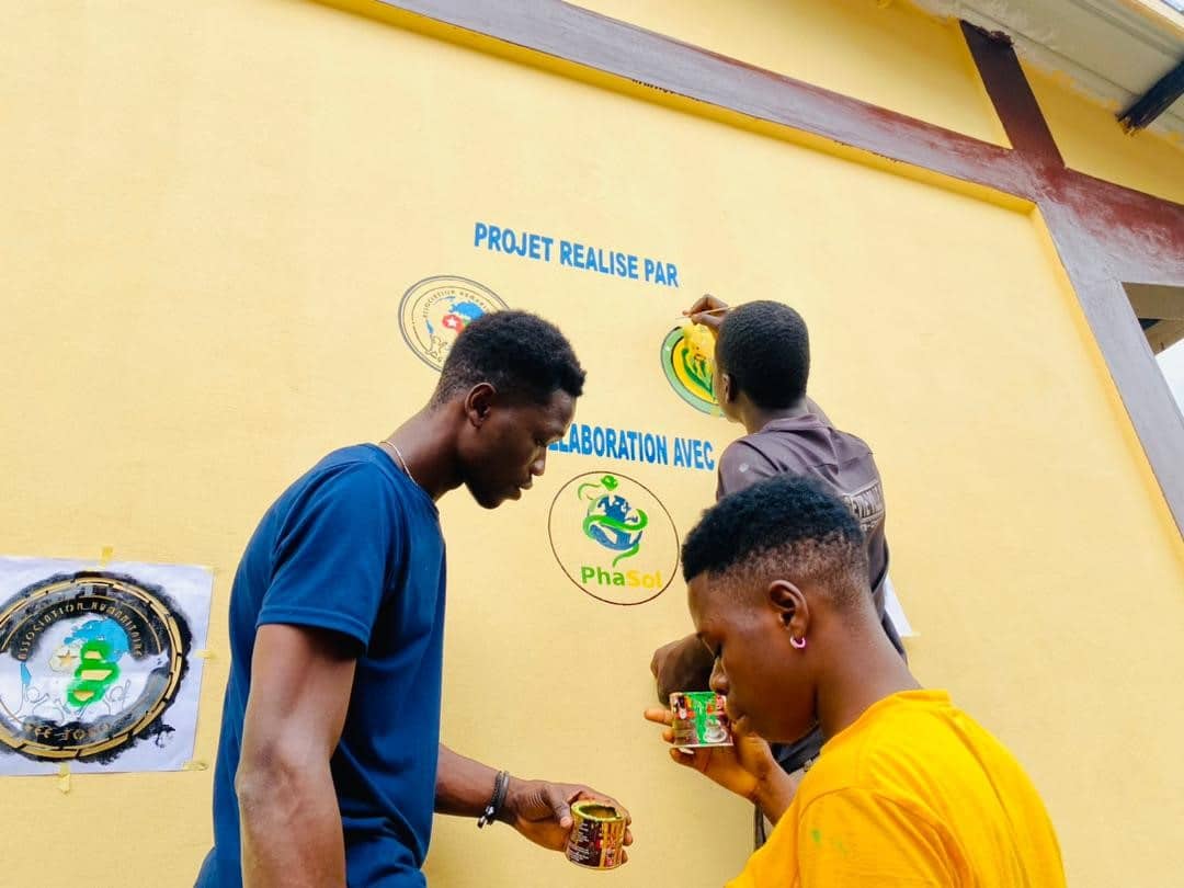 Personnes peignant le logo Phasol sur un mur