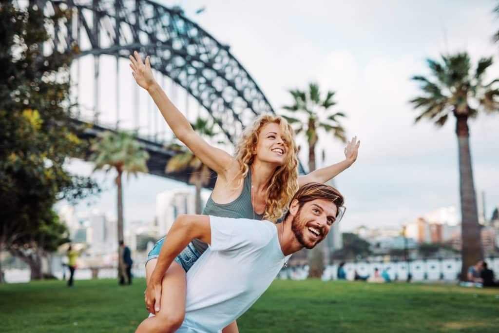 Couple joyeux devant le Harbour Bridge à Sydney