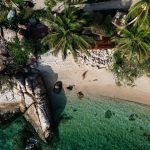 Vue panoramique d'une jeune femme assise sur une plage en Thaïlande