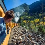 Jeune homme regardant la rivière à travers la fenêtre du train