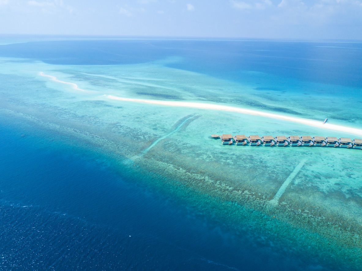 Vue aérienne sur le banc de sable de Kuramathi et ses maisons sur pilotis