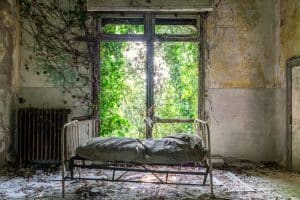 lit d'hôpital devant une fenêtre dans un bâtiment en ruines