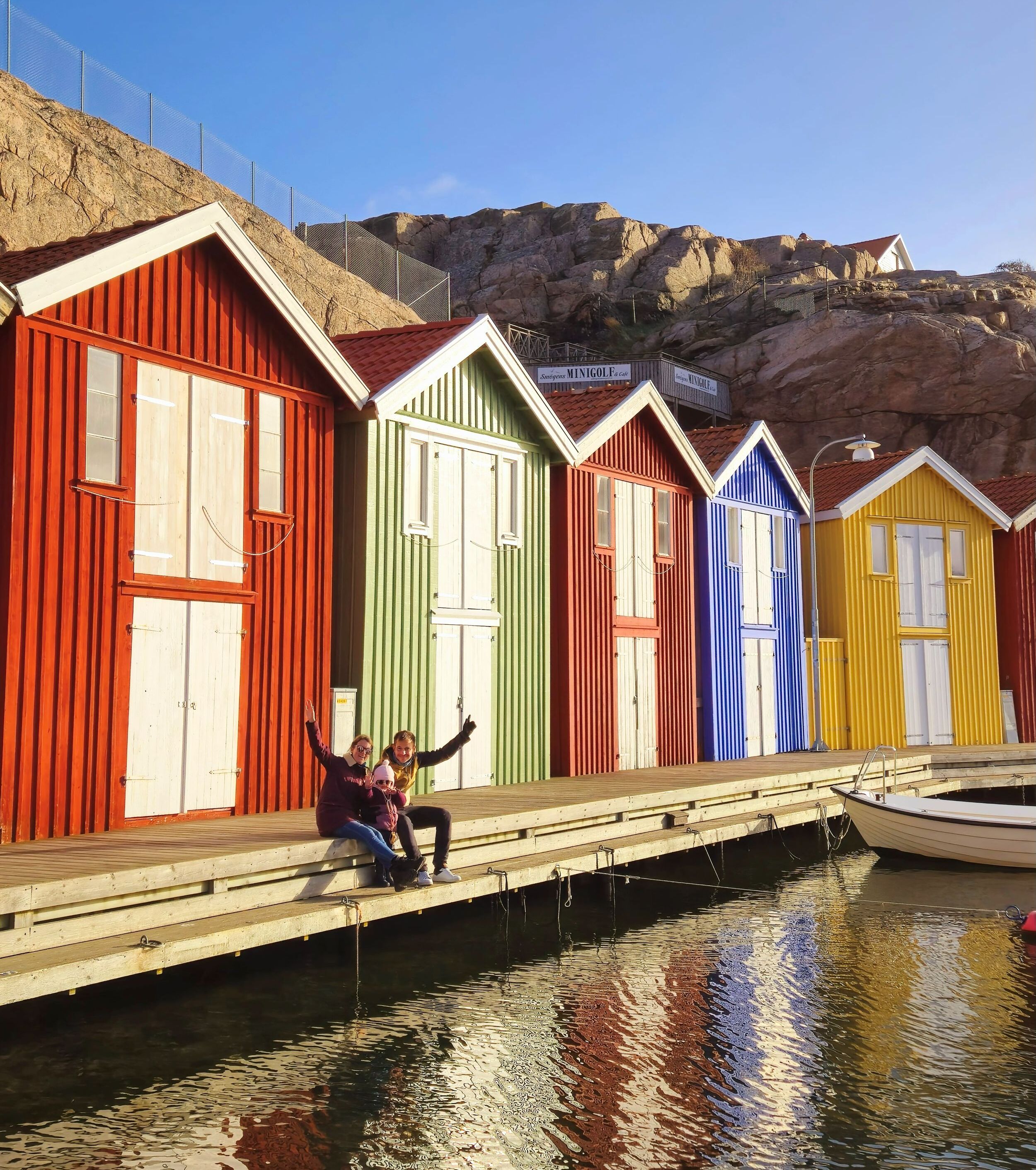 Famille heureuse levant les bras en l'air devant des maisons colorées