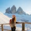 Jeune femme en haut de la montagne admirant les sommets enneigées de Tre Cime