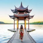 Femme devant un temple chinois face au lac