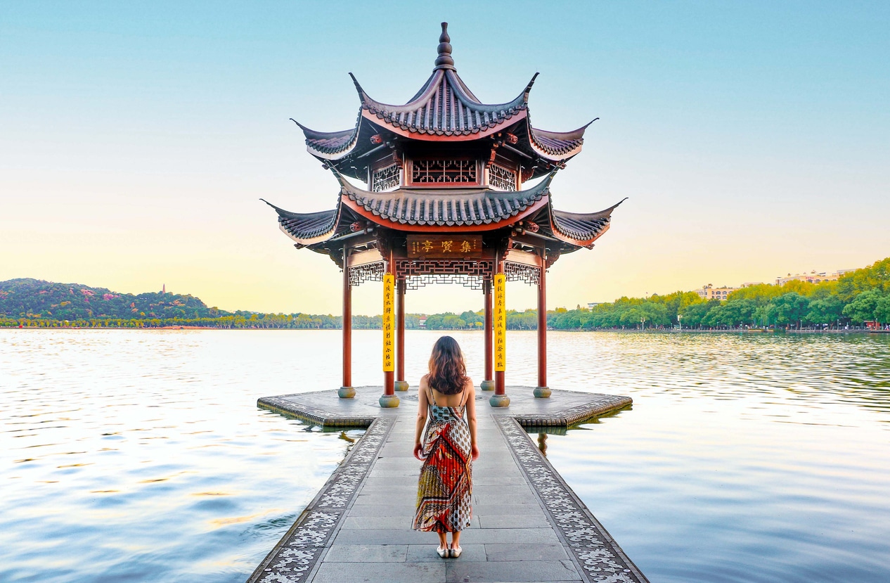 Femme devant un temple chinois face au lac