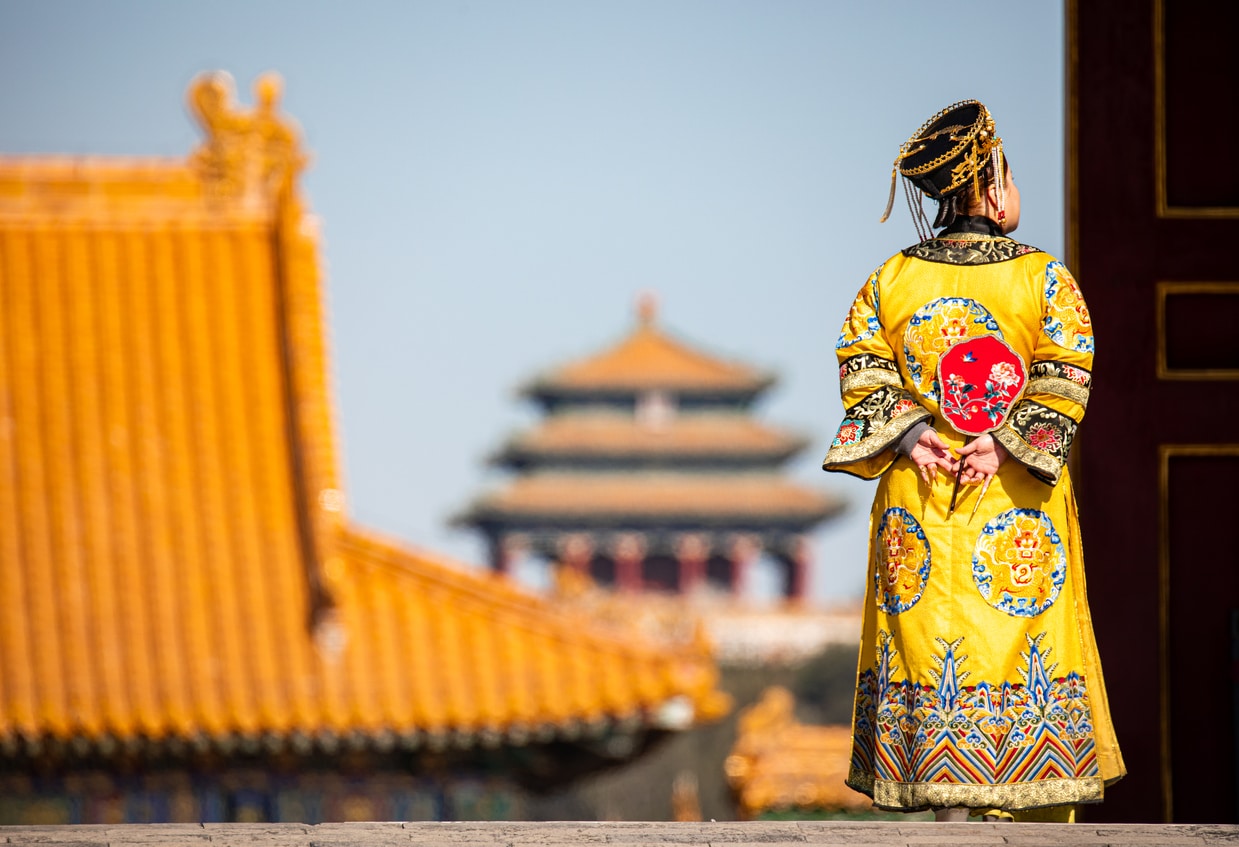 Femme en costume traditionnel devant la cité interdite
